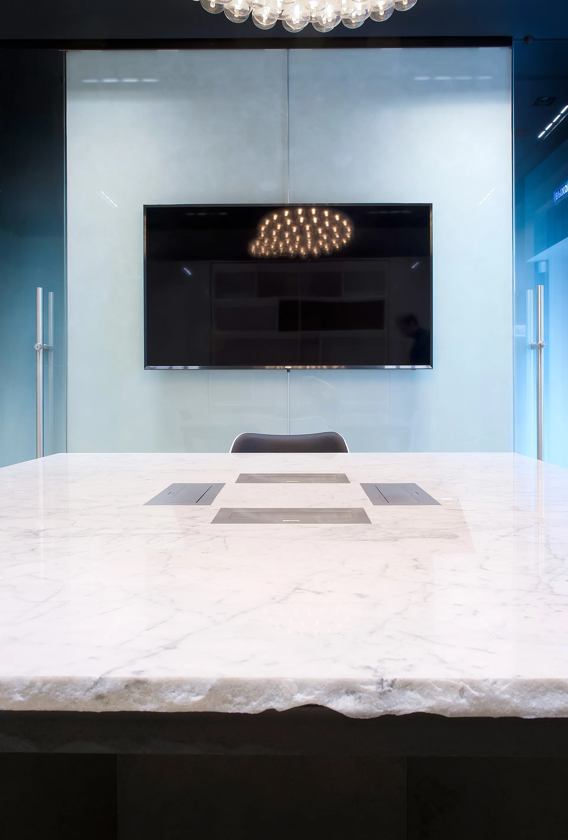 The marble table with integrated sockets in front of the glass partition